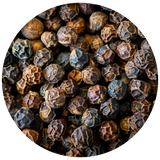 A circular close-up of whole black peppercorns filling the frame, with a white background around the circle.
