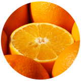A close-up circular photo of bright orange fruit, featuring a cut orange half in the center surrounded by whole oranges on a white background.