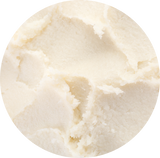 A close-up circular texture shot of  creamy off-white Soy Butter with soft, unevenly blended areas.